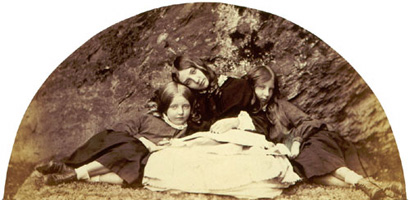 Three young girls sitting on the ground.