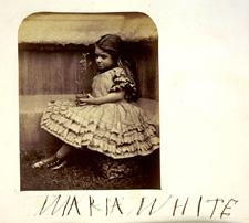 Young girl sitting outside and holding a plant.